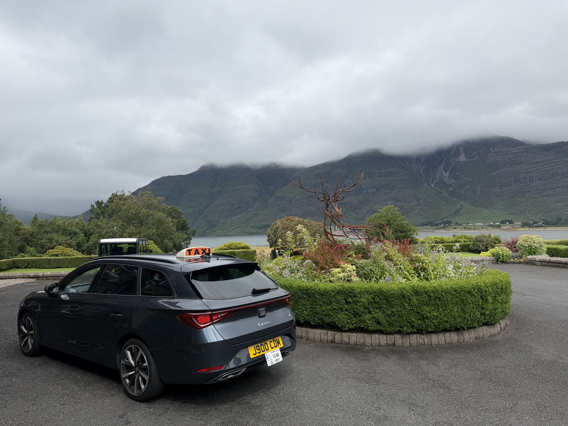 A West Coast Taxis car at The Torridon, with Liathach and Loch Torridon behind